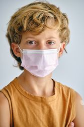 Boy in sterile mask on light background