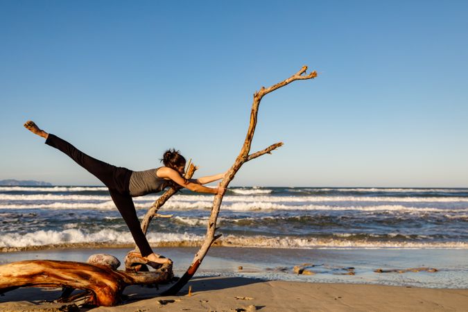 Young woman dancing and posing near water on shore