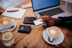 Hand of a man holding a credit card at a coffee shop