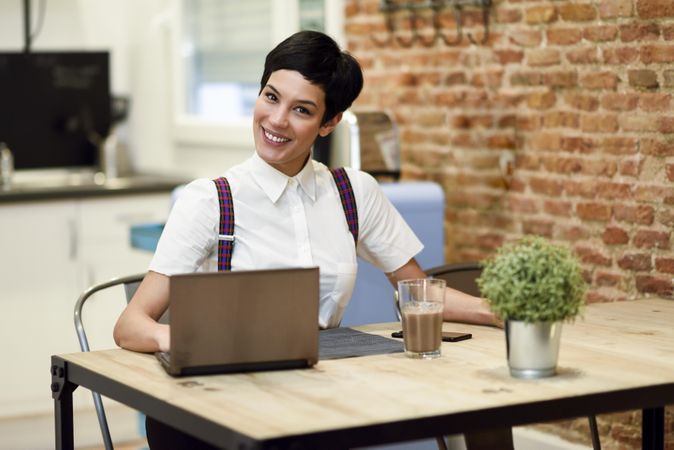 Smiling woman in loft apartment working at home