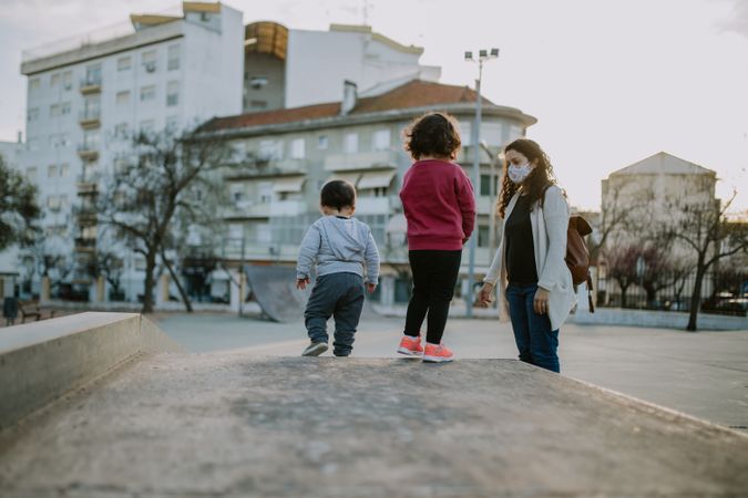 A young family in a skatepark at sunset