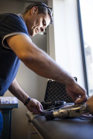 crop man fixing prosthesis in workshop