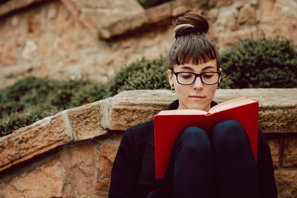 Young woman reading book on steps
