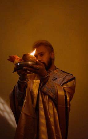 Man in robe holding candles celebrating Diwali
