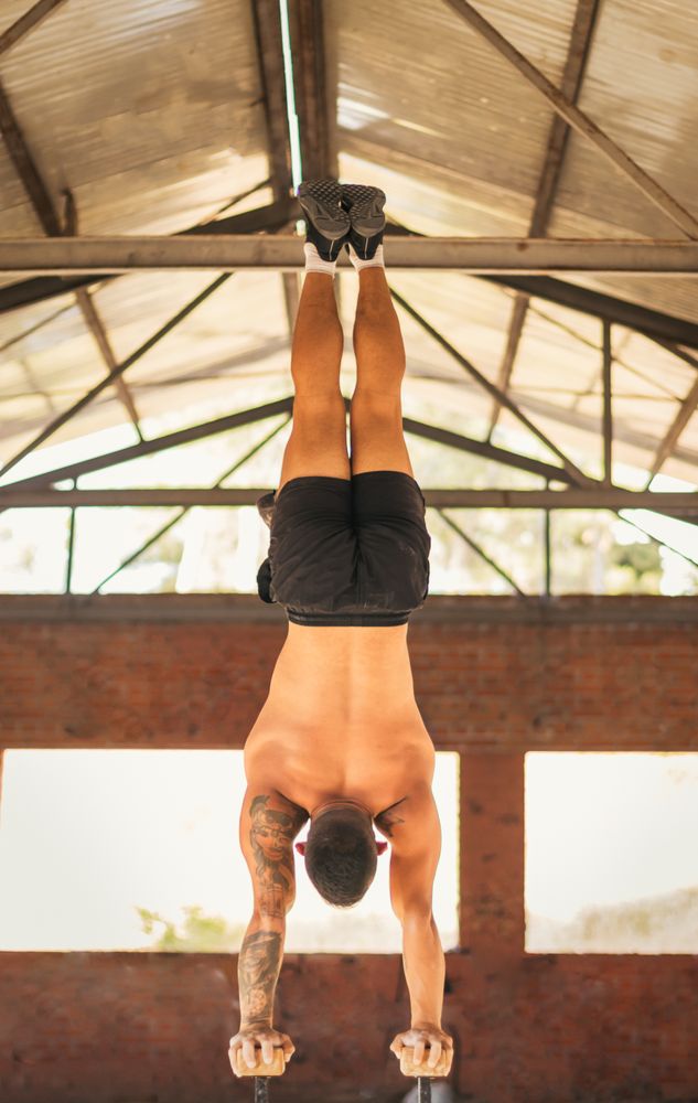 athletic man doing a vertical handstand