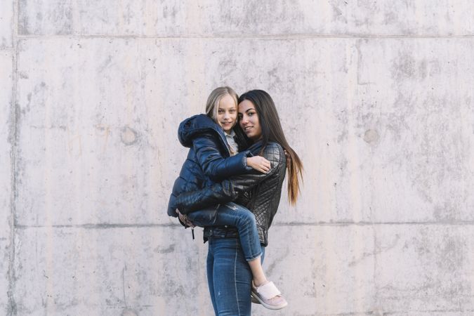 Woman holding up young sister