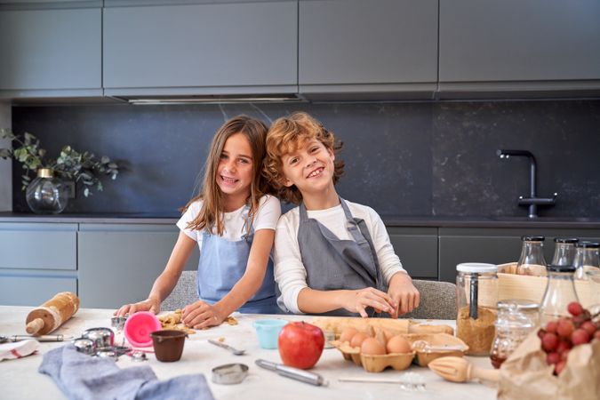 Happy children kneading dough for cookies