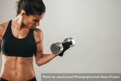 Strong female athlete lifting dumbbell 4ZeaLx