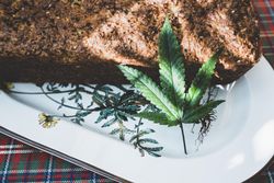 Close up of a baked grainy loaf with a marijuana leaf