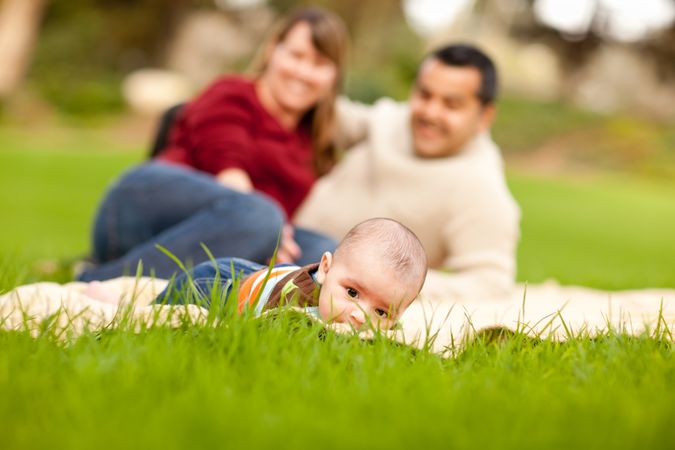 Happy Baby Boy and Parents Playing in the Park