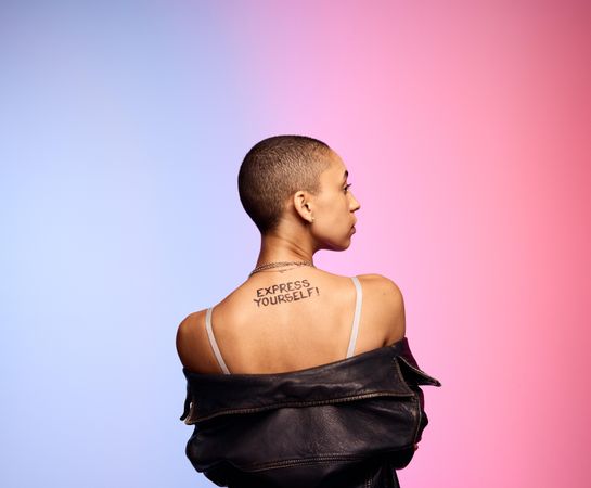 Rear view of bald woman on colorful background