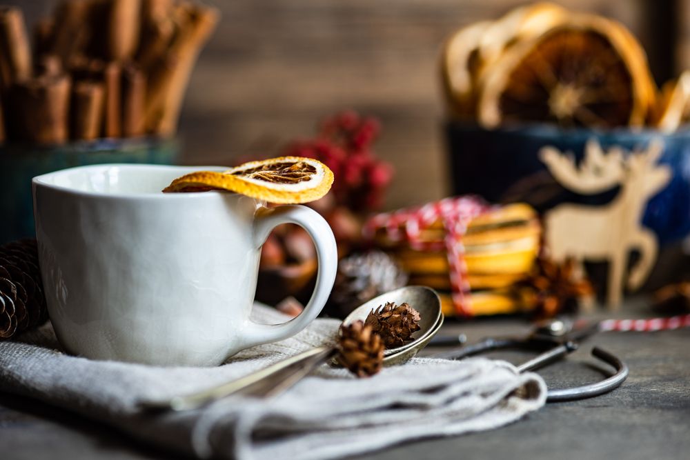 Dried orange slices balanced on mugs of hot tea