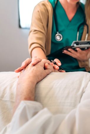 Female doctor comforting older patient