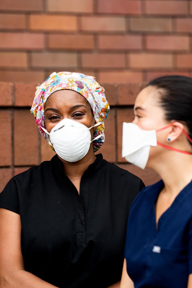 Close up of two nurses talking on break outside together