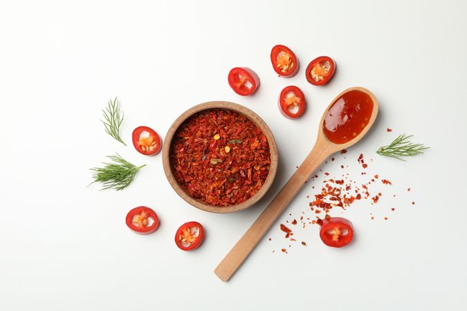 Composition with chilli pepper, spice and sauce on studio background