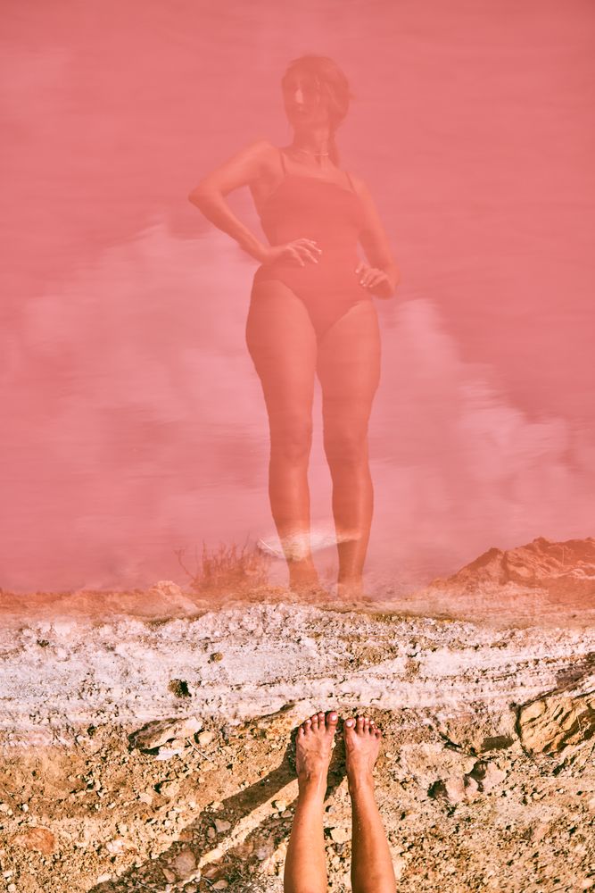 Fit woman in swimsuit posturing on pink lake shore