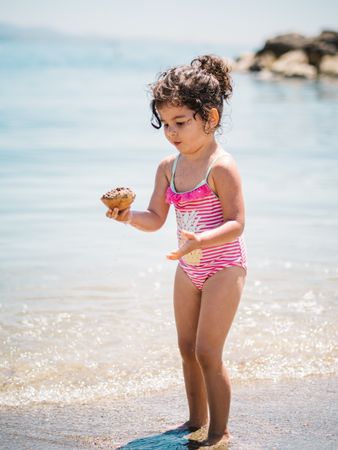 Cute girl playing in water of seaside