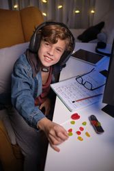 Smiling boy in headphones doing homework