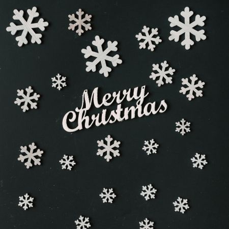 Creative pattern made of snowflakes on dark board with Merry Christmas