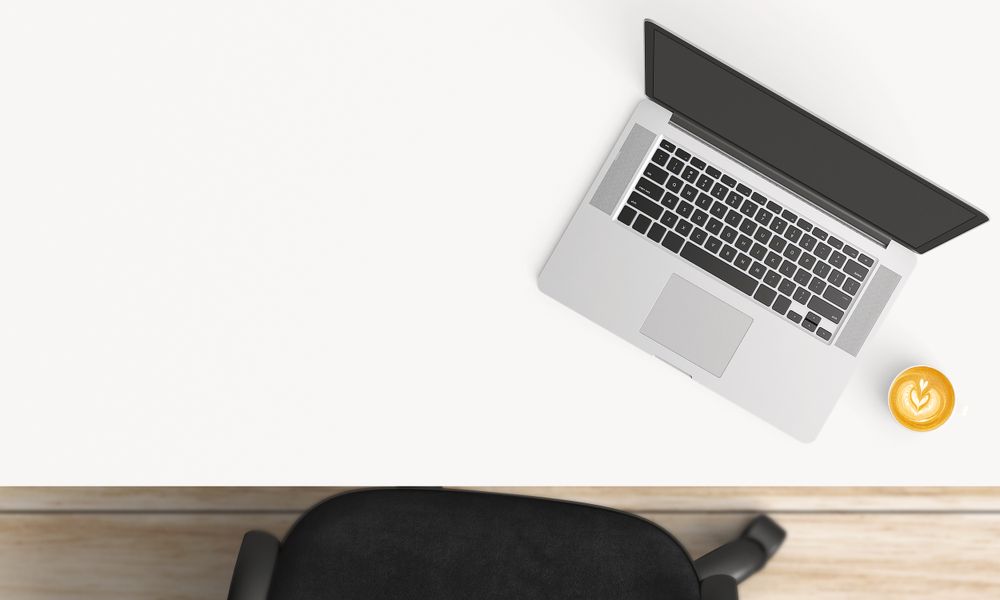 Modern workplace with laptop, coffee cup and notebook copy space on table background. Top view. Flat lay style.