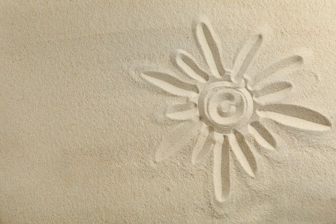 Sun drawing on clear sea sand, space for text and top view. Summer vacation background