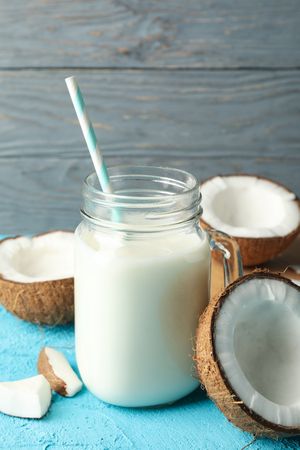 Coconut and milk on blue background, close up