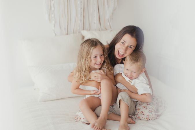 Content young mother with little kids at bedroom