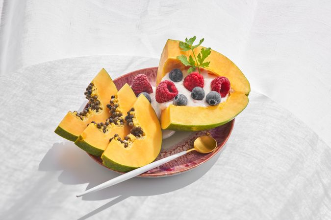 Papaya bowl with berries on plate