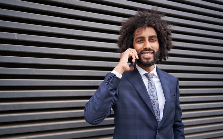 man taking phone near wall