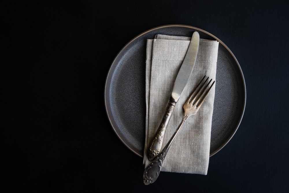 Top view of dark grey plate and napkin