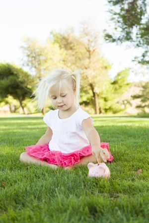Little Girl Having Fun with Her Piggy Bank Outside