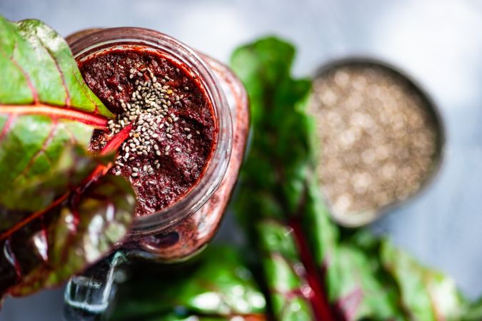 Top view of beet smoothie in mason jar with chia seeds with greens