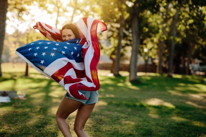 Girl running with USA flag in the park