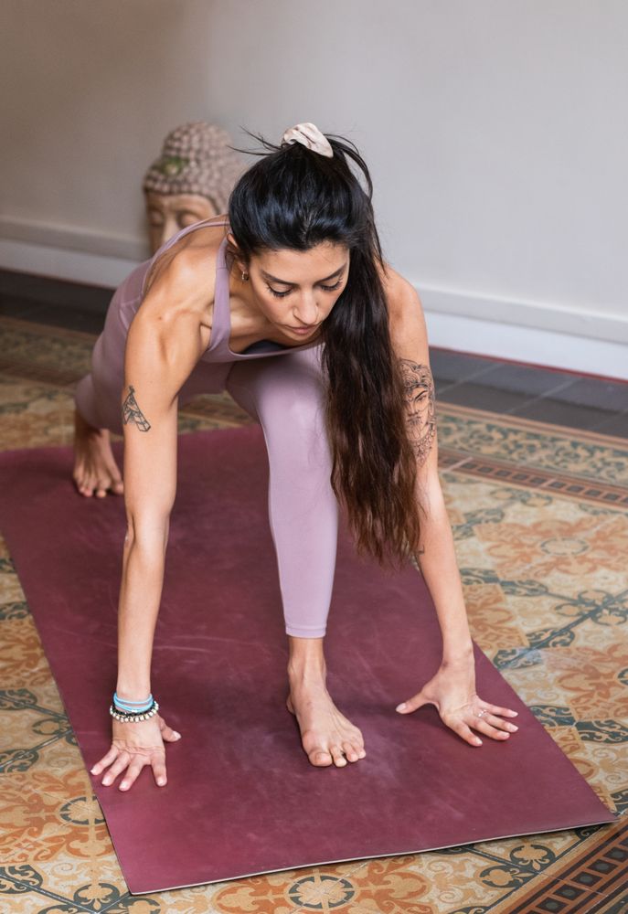 Woman performing Low Lunge pose on yoga mat