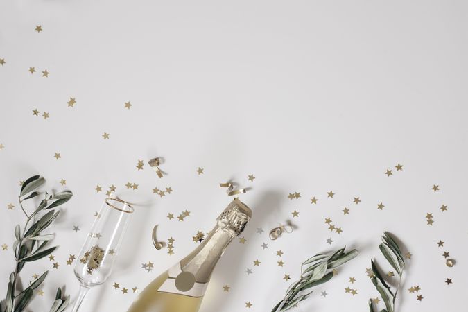 Celebratory decorative border with champagne, branches and confetti