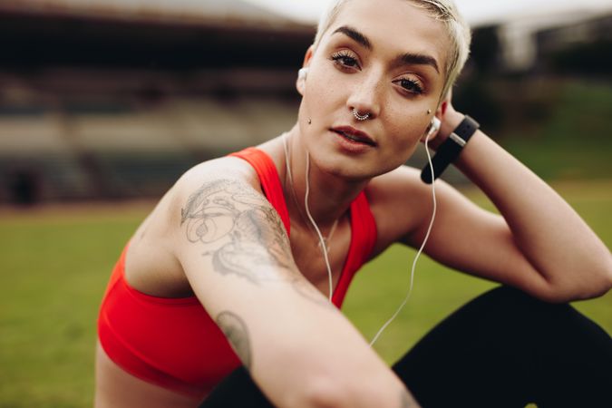 Female athlete relaxing sitting on the ground listening to music