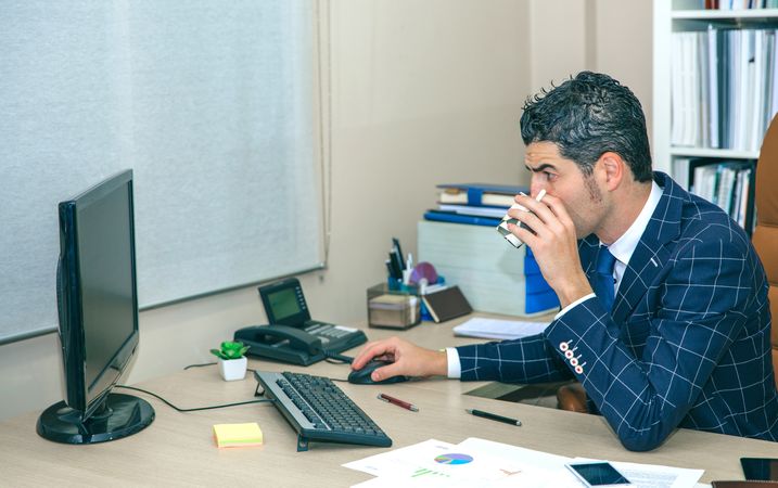 Businessman drinking coffee and working on computer