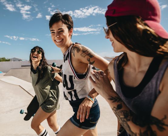 Group of women friends running outdoors at skate park