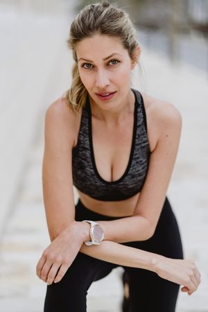 Satisfied sportswoman in active clothing smiling while exercising