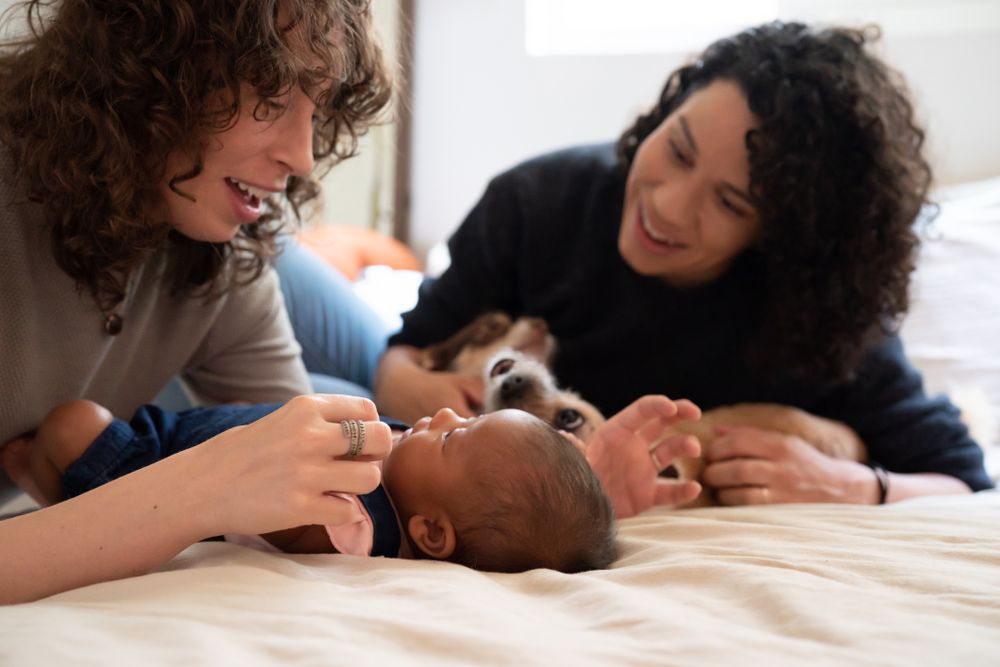 Two women looking down at infant