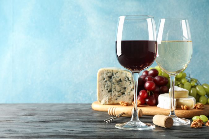 Grape, cheese, corkscrew, glasses with wine, on wooden background, copy space