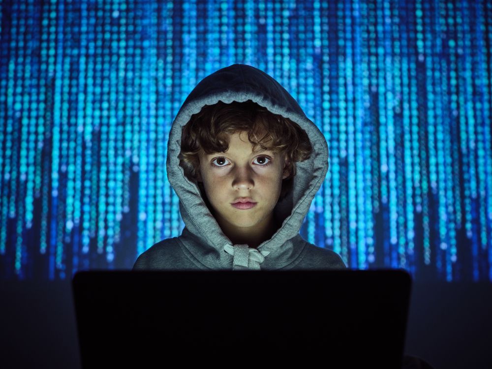 Hacker looking at camera at computer
