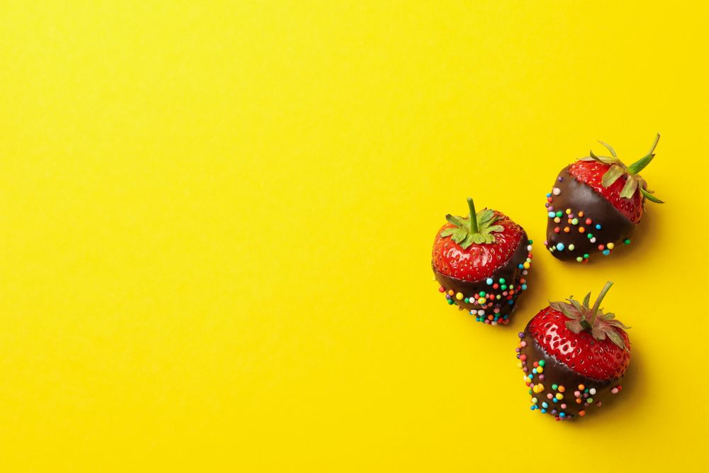 Chocolate fondue. Strawberry in chocolate on yellow background