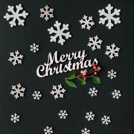 Creative pattern made of snowflakes on dark board with Merry Christmas