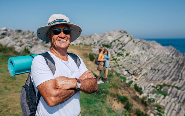 Smiling man in foreground of his hiking crew enjoying view