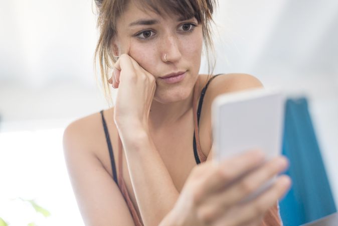 Confused woman reading something on phone
