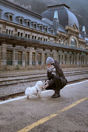 Woman caressing dog at railway platform