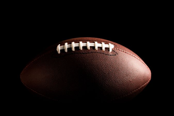 American football ball on dark background