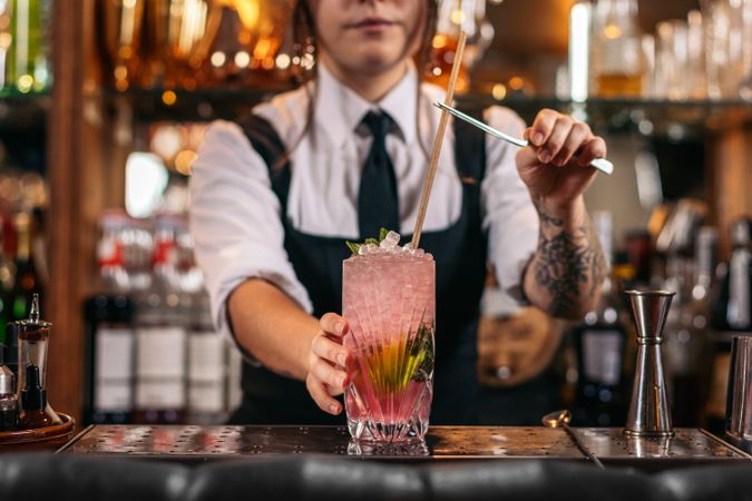 Female bartender preparing a cocktail in a traditional cocktail bar