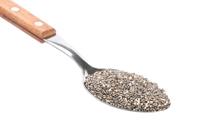 Chia seeds and spoon isolated on plain background